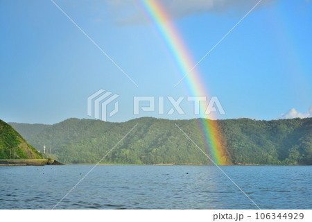 奄美大島　雨上がりの青空と海に架かる虹 106344929