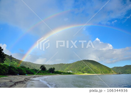 奄美大島　雨上がりの青空と海に架かる虹 106344936