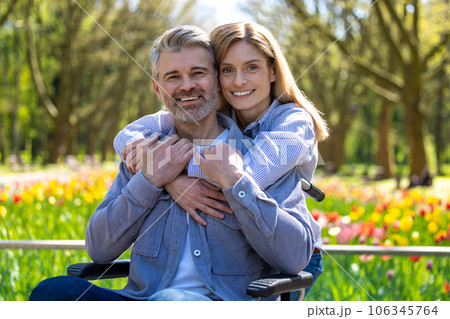 Disabled man with wife walking in park. Disabled man with wife walking in park. 106345764