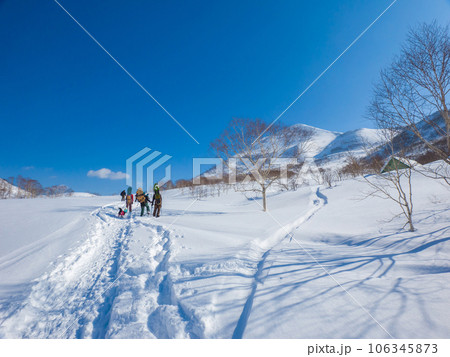 スノーボードを背負って雪原を歩く人々 (北海道、ニセコアンヌプリ北斜面側) 106345873