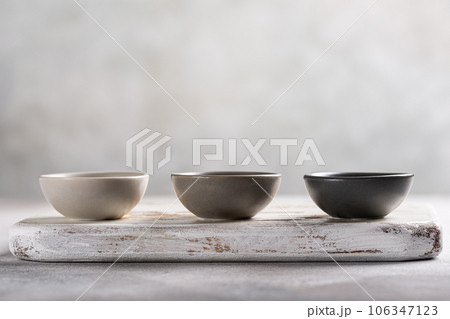 Three empty gray bowls on wooden board 106347123