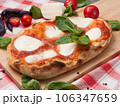 italian pizza with burrata decorated with basil on a wooden board 106347659
