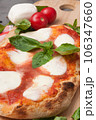 italian pizza with burrata decorated with basil on a wooden board 106347660