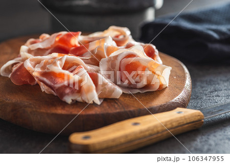 Italian panchetta. Sliced smoked bacon on cutting board. 106347955