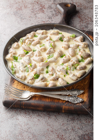 Home cooked chicken hearts in garlic creamy sauce close-up in a plate. Vertical Home cooked chicken hearts in garlic creamy sauce close-up in a plate. Vertical 106348783