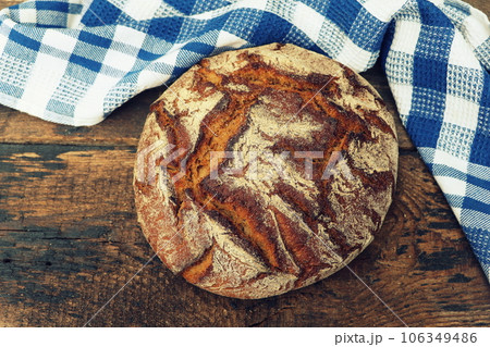 Round loaf of freshly backed sourdough bread, with copy space 106349486