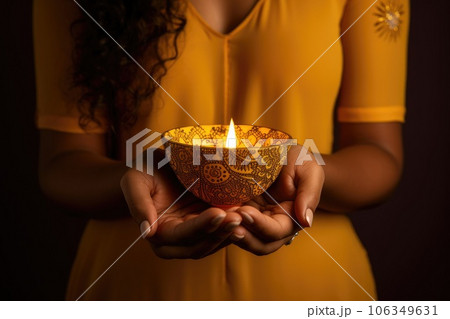 Woman hands with henna holding colorful clay diya lamps lit during diwali celebration 106349631