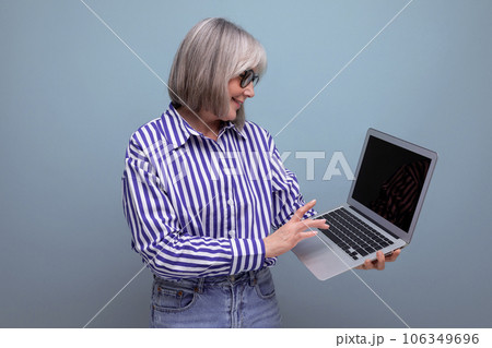 60s middle aged woman master remote professions online using laptop on bright studio background 60s middle aged woman master remote professions online using laptop on bright studio background 106349696