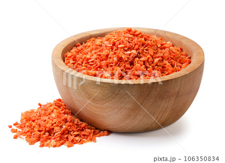Dried carrots in a wooden plate and scattered on a white background. Isolated 106350834