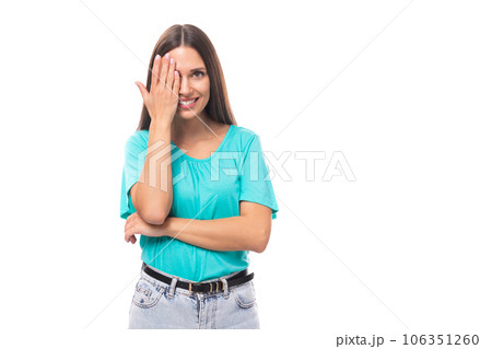young attractive european woman with black long hair dressed in a blue t-shirt looks covering one young attractive european woman with black long hair dressed in a blue t-shirt looks covering one 106351260