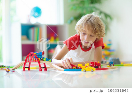 Child with toy train. Kids wooden railway. Child with toy train. Kids wooden railway. 106351643