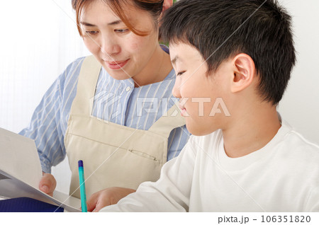 勉強を頑張る男の子と教える母親 106351820