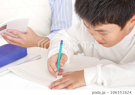 勉強を頑張る男の子と教える母親 勉強を頑張る男の子と教える母親 106351824