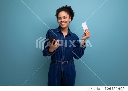 young charming brunette latin woman in blue denim suit holding credit card mockup and smartphone young charming brunette latin woman in blue denim suit holding credit card mockup and smartphone 106351905