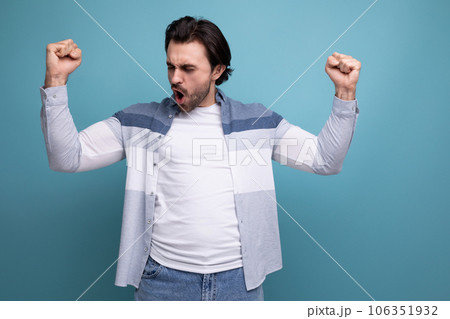 strong joyful young brunette guy on studio background 106351932