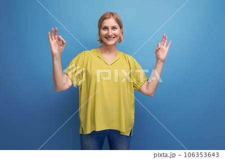middle-aged blond woman in casual dress waving her arms 106353643