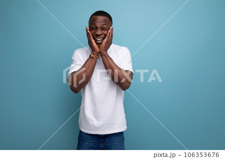 handsome young african man in white t-shirt on blue background with copy space handsome young african man in white t-shirt on blue background with copy space 106353676