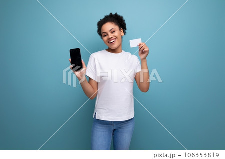 young brunette woman with afro hair in a white t-shirt inspiredly demonstrates the layout of the young brunette woman with afro hair in a white t-shirt inspiredly demonstrates the layout of the 106353819