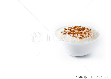 Arroz con leche. Rice pudding with cinnamon in clay bowl isolated on white background. Arroz con leche. Rice pudding with cinnamon in clay bowl isolated on white background. 106353955