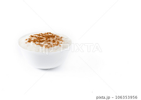 Arroz con leche. Rice pudding with cinnamon in clay bowl isolated on white background. Arroz con leche. Rice pudding with cinnamon in clay bowl isolated on white background. 106353956