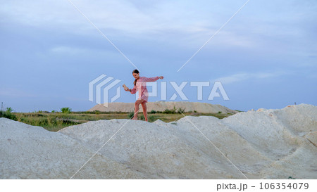 A teenage girl photographs the sunset on a mobile phone, recreation and entertainment for children in nature 106354079