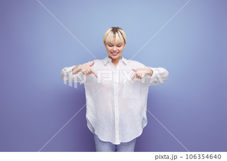 young smart blond career woman in a white shirt points with her hands at an advertising offer young smart blond career woman in a white shirt points with her hands at an advertising offer 106354640