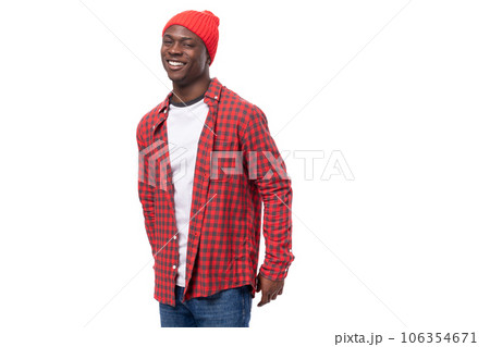 portrait of a dreamy modest 30s black american man dressed in a red shirt and cap on a white studio portrait of a dreamy modest 30s black american man dressed in a red shirt and cap on a white studio 106354671