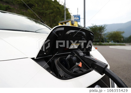 急速充電器で充電する電気自動車の充電口 106355429