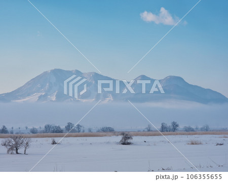 朝霧立ち込める千曲川の雪原から高社山を臨む 106355655