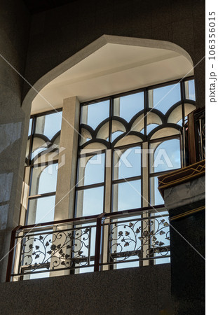 The sunshine lights through the glass window frame and there have wrought iron decorative rails patterns in the corridor. The sunshine lights through the glass window frame and there have wrought iron decorative rails patterns in the corridor. 106356015