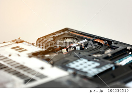 Fixing laptop. Repairman holds cooling fan and repairs from overheating. Disassembling computer, replacement, clean dust and dirt cooling system on notebook. Professional electronic device service 106356519