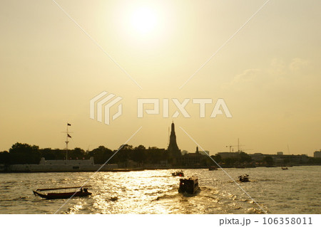 タイ王国バンコクのチャオプラヤー川沿いの寺院「ワット・アルン」と夕焼け 106358011