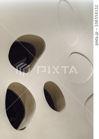 Glass mirrored panels are embedded in the white wall and are decorated in the living room. Glass mirrored panels are embedded in the white wall and are decorated in the living room. 106358132