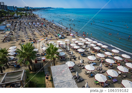Golem, Durres, Albania - 22 august 2023: Aerial view to sandy beach full of umbrellas and people in summer season 2023 Golem, Durres, Albania - 22 august 2023: Aerial view to sandy beach full of umbrellas and people in summer season 2023 106359182