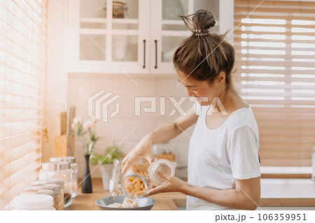 Woman preparing breakfast in the kitchen in the morning. 106359951