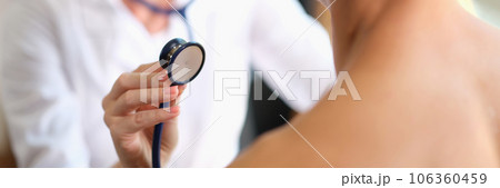 The doctor is touched by a stethoscope in a man, close-up 106360459