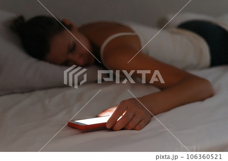 Mobile phone lying in woman's hand while she is sleeping. Mobile phone lying in woman's hand while she is sleeping. 106360521