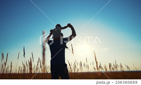 father and son in the park. father's day silhouette happy family child dream concept. father carries his son on his back. dad walk with his son in nature in the park silhouette lifestyle at sunset father and son in the park. father's day silhouette happy family child dream concept. father carries his son on his back. dad walk with his son in nature in the park silhouette lifestyle at sunset 106360689
