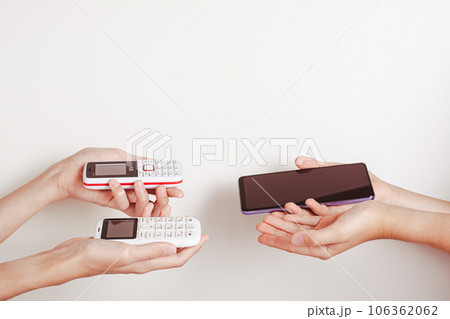 Hands offer an exchange of a push-button phone for a smartphone 106362062