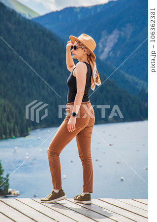Young woman stands in the background Kolsay lake in Kolsai Koldery gorge near Almaty, nature of Kazakhstan National Park, Central Asia Young woman stands in the background Kolsay lake in Kolsai Koldery gorge near Almaty, nature of Kazakhstan National Park, Central Asia 106362381
