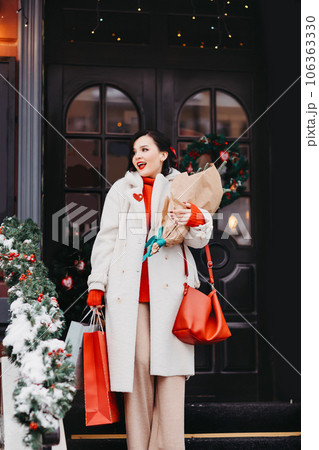 beautiful brunette on the stairs with shopping and a Christmas tree. winter city 106363330