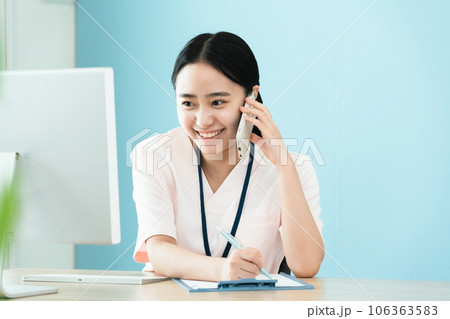 電話で確認をする医療スタッフの女性 106363583