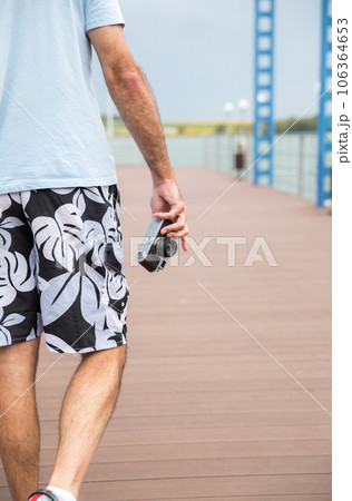 Back view of man holding vintage camera 106364653