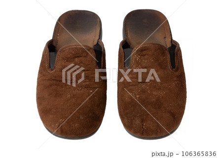 Used brown slippers. Home slippers isolated on white background. 106365836