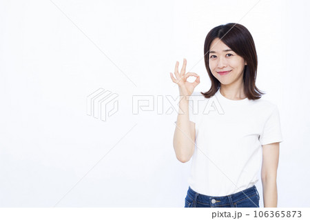 白い背景の前でOKサインをしている30代の女性 白い背景の前でOKサインをしている30代の女性 106365873