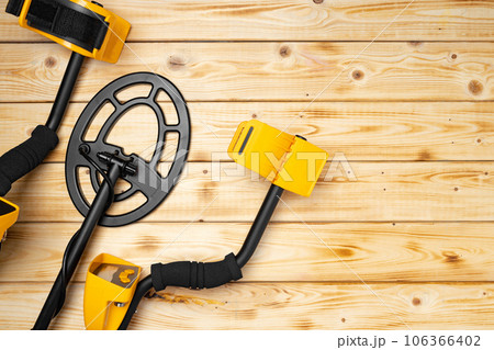 Metal detector on wooden background top view 106366402