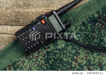 Walkie-talkie and military uniform on wooden surface Walkie-talkie and military uniform on wooden surface 106366421