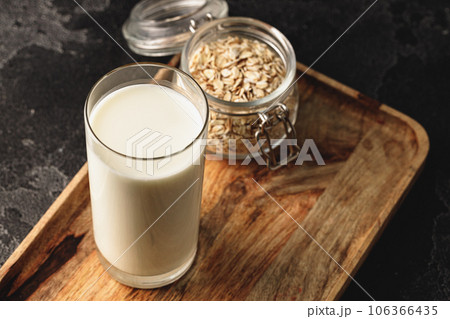 Vegan oat milk with oat flakes close up 106366435
