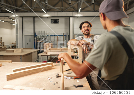 Two young men carpenters making furniture in warehouse of wood factory Two young men carpenters making furniture in warehouse of wood factory 106366553