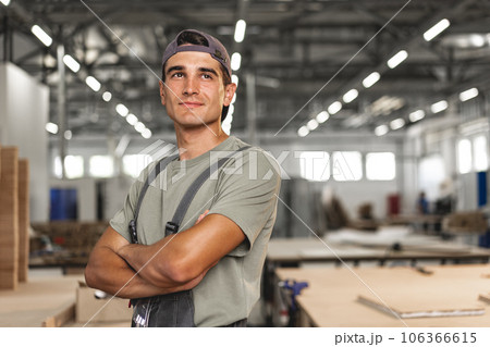 Portrait of young male carpenter standing in the wood workshop Portrait of young male carpenter standing in the wood workshop 106366615